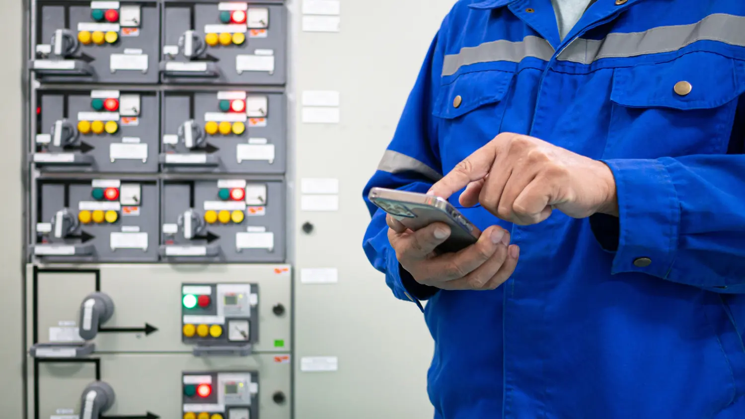 Celero Cloud GmbH – Arbeiter in Uniform analysiert Daten mit einem schweren System im Hintergrund