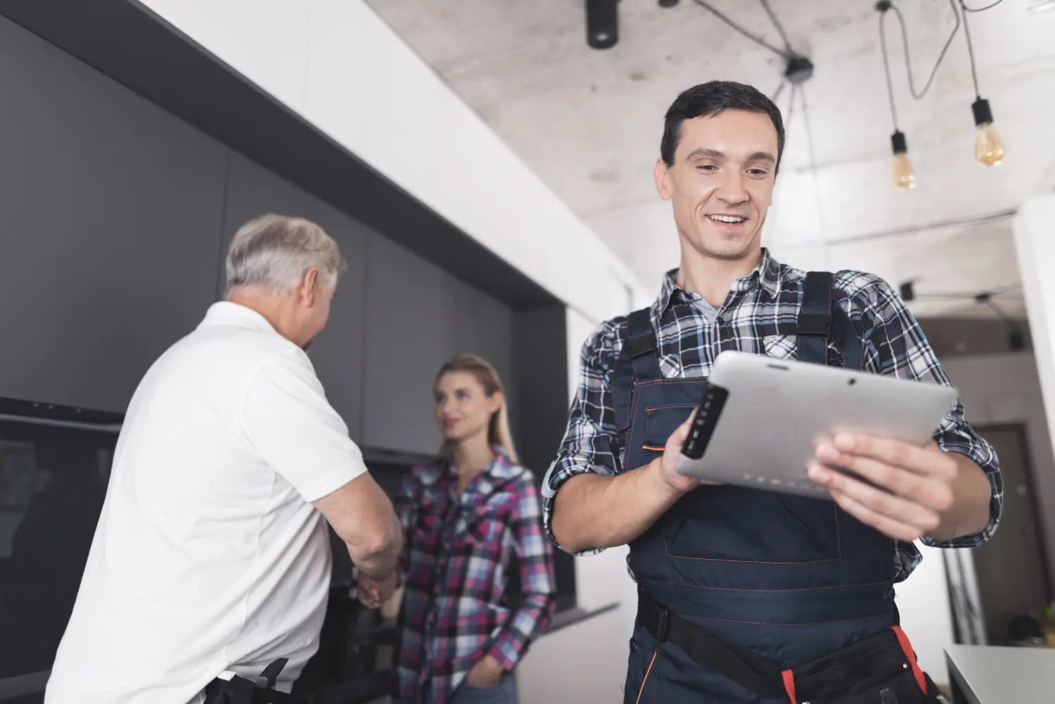 Celero Cloud GmbH- happy man analysing data on tab while a man and a woman shaking hand in background